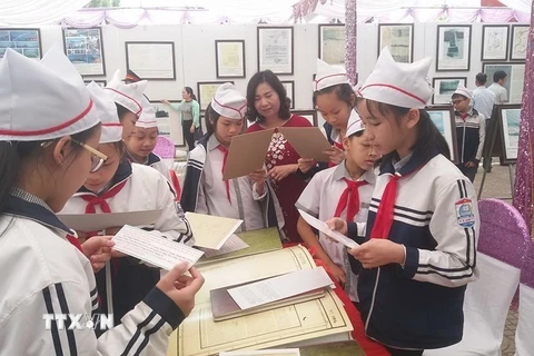 Học sinh huyện Lạc Thủy tham quan triển lãm. (Ảnh: Nhan Sinh/TTXVN)