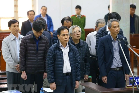 Bị cáo Hoàng Thế Trung (áo khoác màu đen đứng hàng đầu) và các bị cáo nghe tòa tuyên án. (Ảnh: Doãn Tấn/TTXVN)