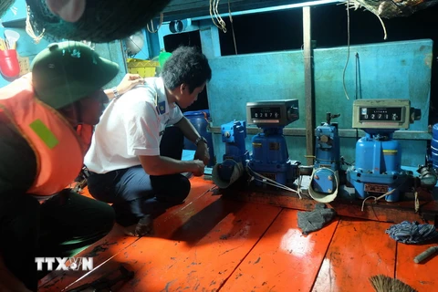Lực lượng Cảnh sát biển đang kiểm tra đồng hồ bơm và sang chiết dầu. (Ảnh minh họa: Phúc Sơn/TTXVN)