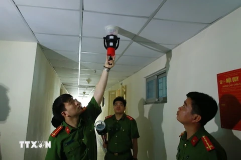 Cảnh sát phòng cháy, chữa cháy kiểm tra hệ thống báo cháy tại chung cư HH Linh Đàm. (Ảnh: TTXVN)