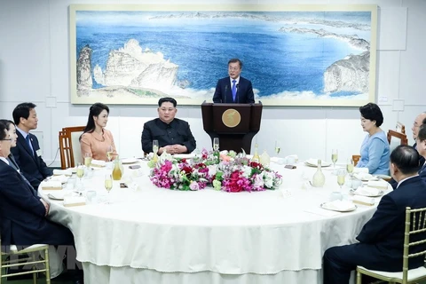 Nhà lãnh đạo Triều Tiên Kim Jong-un (thứ 5, trái) cùng phu nhân Ri Sol Ju (thứ 4, trái), Tổng thống Hàn Quốc Moon Jae-in (phía sau) cùng phu nhân Kim Jung-sook (thứ tư, phải) dự tiệc mừng tại làng đình chiến Panmunjom ngày 27/4. (Nguồn: Yonhap/TTXVN)