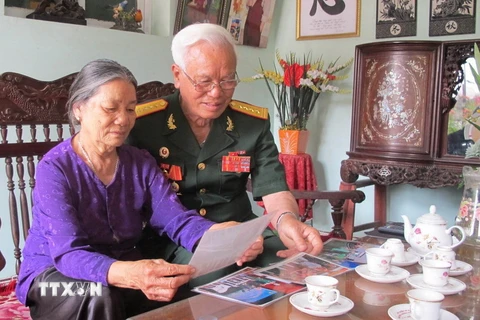 Đại tá Trịnh Xuân Ứng xem lại những kỷ vật xưa. (Ảnh: Hải Yến/TTXVN)