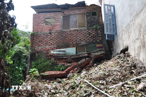 Một căn nhà ở ấp Thái Hòa đứng chơ vơ chờ sập. (Ảnh: Công Phong/TTXVN)