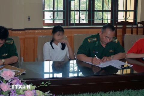 Lực lượng chức năng tiến hành bàn giao 2 nạn nhân cho gia đình. (Ảnh: Nguyễn Hoàng/TTXVN)