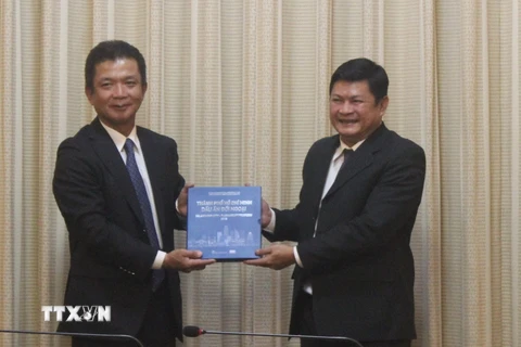 Phó Chủ tịch Ủy ban Nhân dân Thành phố Hồ Chí Minh Huỳnh Cách Mạng tặng quà lưu niệm cho ông Kadowaki Keiichi. (Ảnh: Xuân Anh/TTXVN)