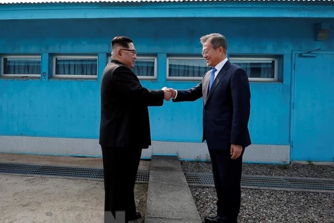 Tổng thống Hàn Quốc Moon Jae-in (phải) và nhà lãnh đạo Triều Tiên Kim Jong-un bắt tay hữu nghị tại đường phân định ranh giới hai miền ở làng đình chiến Panmunjom ngày 27/4. (Nguồn: Yonhap/TTXVN)