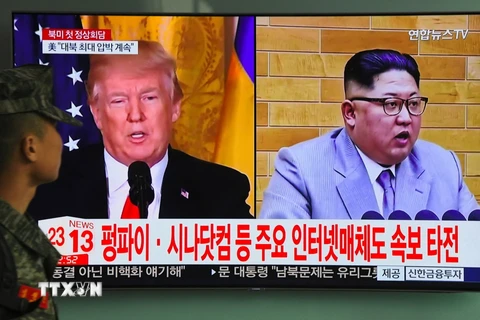 Người dân theo dõi qua truyền hình hình ảnh Tổng thống Mỹ Donald Trump (trái) và nhà lãnh đạo Triều Tiên Kim Jong-un, ngày 9/3. AFP/ TTXVN.
