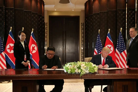 Tổng thống Mỹ Donald Trump (phải) và nhà lãnh đạo Triều Tiên Kim Jong-un ký văn kiện chung. (Nguồn: Reuters)