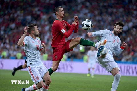 Cầu thủ Cristiano Ronaldo (giữa) đội tuyển Bồ Đào Nha tả xung hữu đột trước các cầu thủ Tây Ban Nha. (Ảnh: THX/TTXVN)