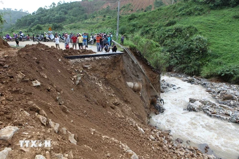 Đoạn đường bị đứt 30m do mưa lũ gây ra tại km 369, quốc lộ 32 huyện Tân Uyên đi Than Uyên khiến giao thông chia cắt. (Ảnh: Quý Trung/TTXVN)