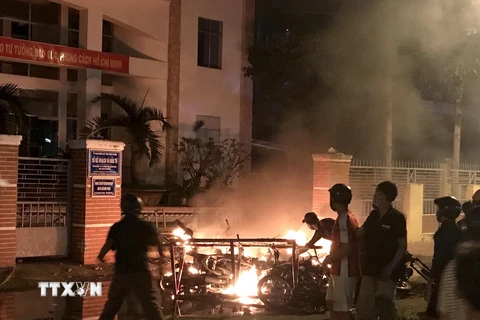 Một số đối tượng quá khích lôi xe máy từ trong Sở Kế hoạch và Đầu tư tỉnh Bình Thuận ra đốt phá ngày 10/6/2018. (Ảnh: Nguyễn Thanh/TTXVN)