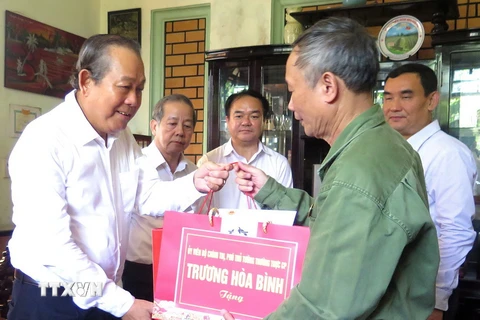 Phó Thủ tướng Thường trực Chính phủ Trương Hòa Bình thăm, tặng quà thương binh Phạm Văn Giới, phường Thuận Hòa, thành phố Huế. (Ảnh: Tường Vi/TTXVN)