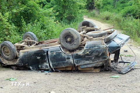 Chiếc xe chở theo nhiều thanh gỗ xẻ không có dấu búa kiểm lâm, bị lật ngửa sau vụ tai nạn. (Ảnh: TTXVN)