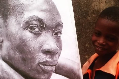 Cậu bé Kareem Waris Olamilekan và một bức tranh do cậu vẽ. (Nguồn: odditycentral.com)