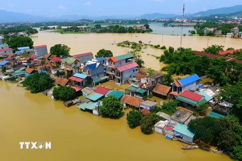 Nhiều điểm dân cư ở thôn Bùi Xá vẫn chìm trong nước lũ. (Ảnh: Nguyễn Thắng/TTXVN)