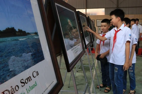 Các em học sinh tham quan triển lãm về Trường Sa, Hoàng Sa của Việt Nam. (Ảnh: Vũ Hoàng Giang/TTXVN) 