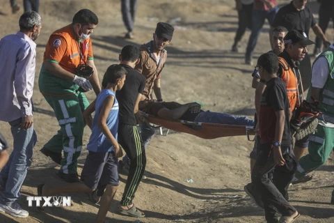  Chuyển người bị thương trong xung đột giữa binh sỹ Israel với người biểu tình Palestine tại khu vực biên giới giữa Dải Gaza với Israel ngày 27/7. (Nguồn: THX/TTXVN)