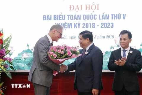 Ngài Wolfgang Manig, Đại biện Lâm thời Đại sứ quán Cộng hòa Liên bang Đức tại Việt Nam tặng hoa tân Chủ tịch Hội Hữu nghị Việt Nam-Đức, ông Nguyễn Chí Dũng. (Ảnh: Văn Điệp/TTXVN)