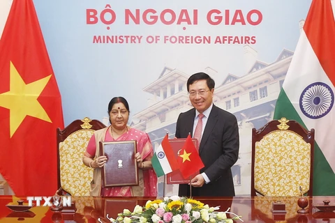 Phó Thủ tướng, Bộ trưởng Bộ Ngoại giao Phạm Bình Minh và Bộ trưởng Bộ Ngoại giao Ấn Độ Sushma Swaraj tại lễ ký Biên bản thỏa thuận của Kỳ họp. (Ảnh: Lâm Khánh/TTXVN)