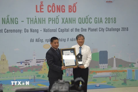Đại diện Tổ chức Bảo tồn thiên nhiên quốc tế (WWF) tại Việt Nam (trái) trao danh hiệu Thành phố xanh quốc gia của Việt Nam cho thành phố Đà Nẵng. (Ảnh: Đinh Văn Nhiều/TTXVN)