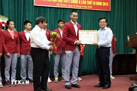 Lãnh đạo tỉnh Hải Dương trao bằng khen, tiền thưởng cho vận động viên Trần Đình Nam, môn Pencak Silat đã giành được huy chương vàng tại Đại hội. (Ảnh: Mạnh Tú/TTXVN)