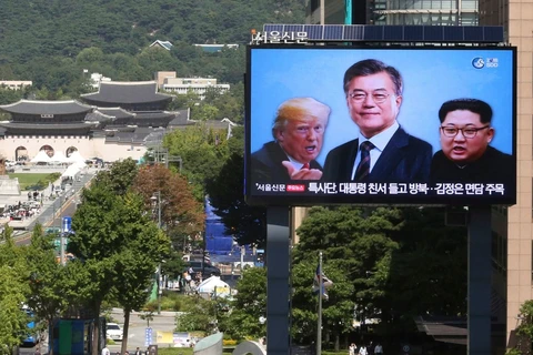 Một màn hình lớn có hình ảnh của Tổng thống Mỹ Donald Trump (trái), Tổng thống Hàn Quốc Moon Jae-in (giữa) và nhà lãnh đạo Triều Tiên Kim Jong-un. (Nguồn: AP)