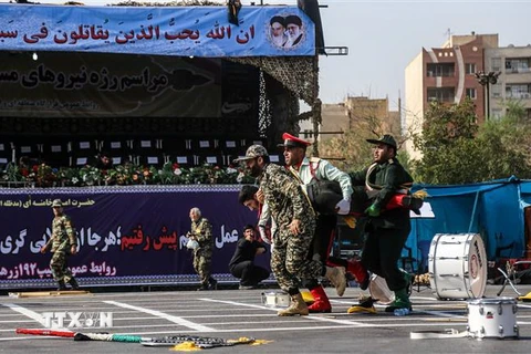 Binh sỹ Iran chuyển nạn nhân bị thương trong vụ tấn công nhằm vào lễ diễu binh ở thành phố Ahvaz. (Ảnh: AFP/TTXVN)