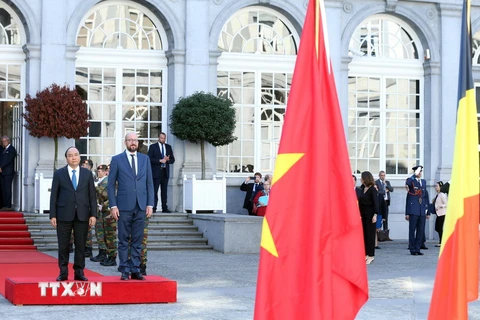 Thủ tướng Vương quốc Bỉ Charles Michel và Thủ tướng Nguyễn Xuân Phúc trên bục danh dự, nghe quân nhạc cử Quốc thiều hai nước, tại lễ đón. (Ảnh: Thống Nhất/TTXVN)