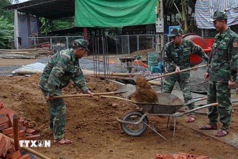 Các chiến sỹ Đồn Biên phòng Mường Cai giúp đồng bào vùng biên xây nhà. (Ảnh: Hữu Quyết/TTXVN)