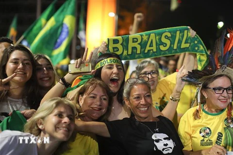 Những người ủng hộ ứng viên đảng Xã hội Tự do (PSL) Jair Bolsonaro vui mừng sau khi kết quả kiểm phiếu sơ bộ được công bố, tại Brasilia ngày 28/10/2018. (Ảnh: AFP/TTXVN)