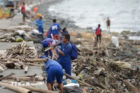 Người dân dọn dẹp đống đổ nát do bão Yutu tại Manila, Philippines ngày 30/10/2018. (Ảnh: AFP/TTXVN)