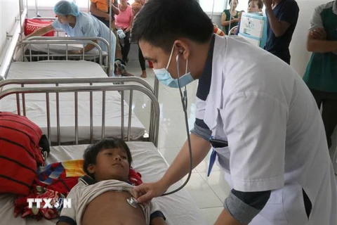 Các bác sỹ tại Bệnh viện Nhi tỉnh Gia Lai thăm khám cho em Đinh Đang bị ngộ độc do ăn thịt cóc. (Ảnh: Dư Toán/TTXVN)