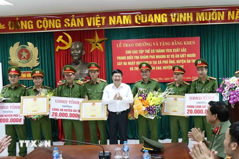 Chủ tịch Ủy ban Nhân dân tỉnh Hưng Yên Nguyễn Văn Phóng trao tiền thưởng và bằng khen cho đại diện các lực lượng phá án 2 vụ giết người. (Ảnh: Đinh Tuấn/TTXVN)