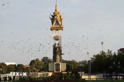 Chim bồ câu hòa bình tung cách bay trước Đài Hữu nghị Việt Nam-Campuchia ở thủ đô Phnom Penh ngày diễn ra lễ kỷ niệm 65 năm Quốc khánh Campuchia. (Ảnh: TTXVN)