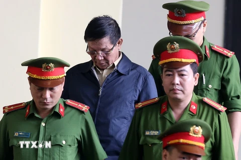 Lực lượng chức năng dẫn giải bị cáo Phan Văn Vĩnh vào tòa. (Ảnh: Trung Kiên/TTXVN)