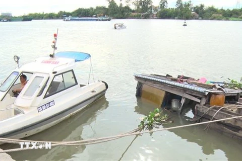 Lực lượng chức năng Đồng Nai bảo vệ hiện trường phối hợp với các đơn vị bơm hút hóa chất bị chìm dưới sông tránh nguy cơ tràn hóa chất. (Ảnh: Sỹ Tuyên/TTXVN)