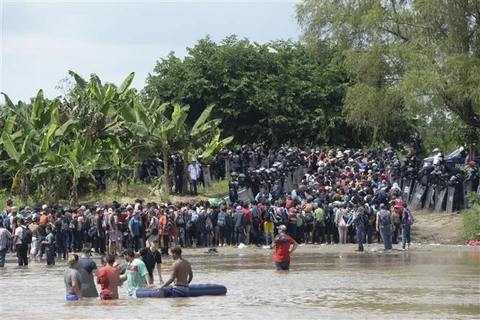 Người di cư băng qua sông Suchiate từ Ciudad Tecun Uman (Guatemala) để tới Ciudad Hidalgo (Mexico) trong hành trình đến Mỹ, ngày 29/10/2018. (Ảnh: AFP/TTXVN)