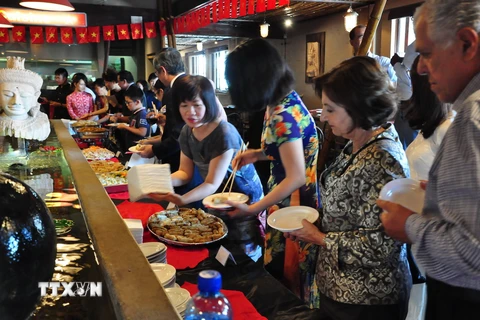 Quan khách nhiệt tình thưởng thức các món ăn Việt Nam. (Ảnh: Đình Lượng/TTXVN)
