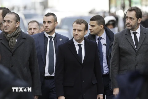 Tổng thống Pháp Emmanuel Macron (giữa, phía trước) và các quan chức Chính phủ thị sát một tuyến phố ở thủ đô Paris, nơi nổ ra các cuộc biểu tình bạo loạn của lực lượng 'Áo vàng' nhằm phản đối tăng giá nhiên liệu, ngày 2/12/2018. (Ảnh: AFP/TTXVN)