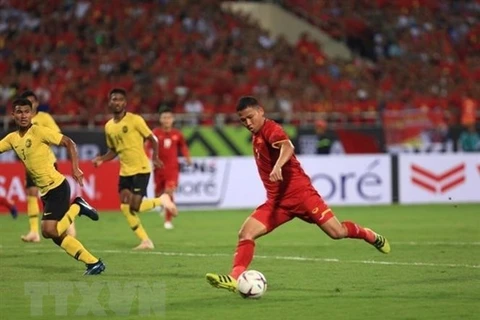 Cầu thủ của Việt Nam đột phá trong vòng vây của ba hậu vệ đội Malaysia. (Ảnh: Trọng Đạt/TTXVN)