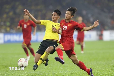 Phan Văn Đức tranh bóng với hậu vệ Malaysia. (Ảnh: Hoàng Linh/TTXVN)