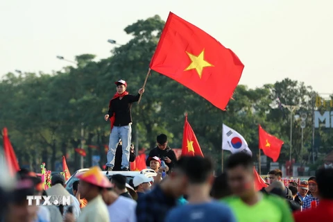 Cổ động viên cổ vũ đội tuyển Việt Nam bên ngoài sân vận động Mỹ Đình. (Ảnh: Thành Đạt/TTXVN)