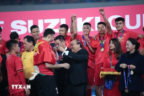 Thủ tướng Nguyễn Xuân Phúc trao huy chương vô địch AFF Suzuki Cup 2018 cho thủ môn Đặng Văn Lâm và các cầu thủ đội tuyển Việt Nam. (Ảnh: Trọng Đạt/TTXVN)