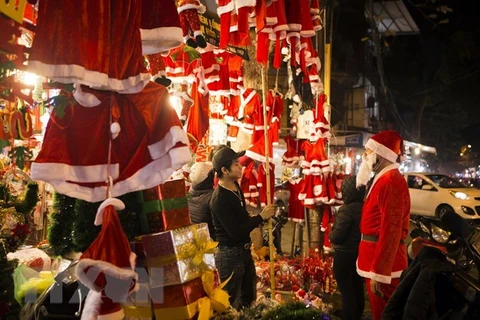 Du khách tham quan và chọn mua các mặt hàng trang trí đón Giáng sinh trên phố Hàng Mã. (Ảnh: Hoàng Hùng/TTXVN)