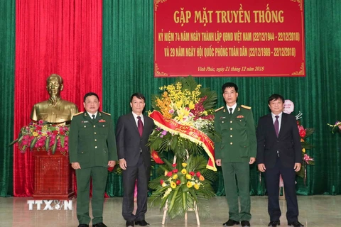 Tổng giám đốc TTXVN Nguyễn Đức Lợi tặng hoa chúc mừng Sư đoàn 304. (Ảnh: Văn Điệp/TTXVN)