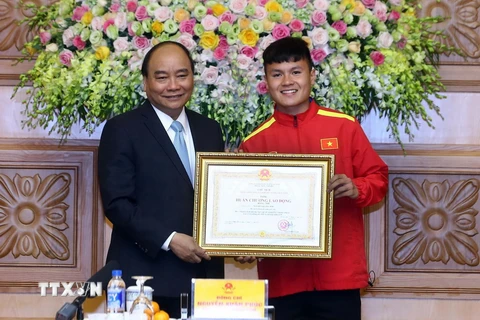 Thủ tướng Nguyễn Xuân Phúc trao tặng Huân chương lao động Hạng Nhì cho cầu thủ Nguyễn Quang Hải. (Ảnh: Thống Nhất/TTXVN)