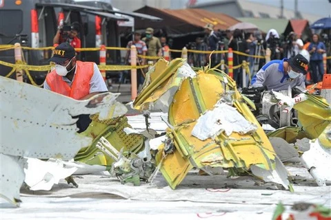 Các nhà điều tra kiểm tra mảnh vỡ máy bay của hãng hàng không Lion Air tại cảng Tanjung Priok, Jakarta của Indonesia. (Ảnh: THX/TTXVN)