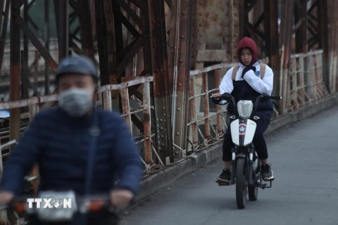 Người dân Thủ đô cảm nhận rõ cái lạnh khi lưu thông qua cầu Long Biên. Ảnh: Minh Hoàng - TTXVN phát