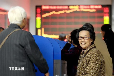 Nhà đầu tư theo dõi tỷ giá chứng khoán tại sàn giao dịch chứng khoán ở tỉnh An Huy, Trung Quốc. (Ảnh: THX/TTXVN)