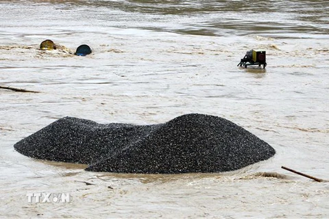 Nhiều phương tiện máy móc của đơn vị khai thác cát, sỏi bị chìm trong nước lũ. (Ảnh: Quốc Khánh/TTXVN)